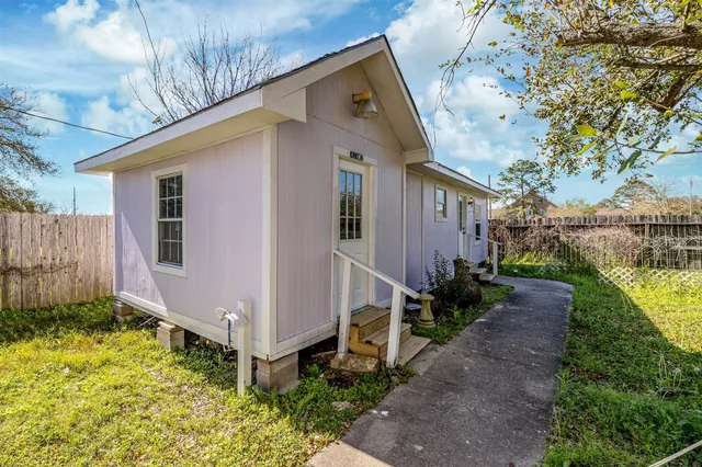 a front view of house with yard and trees in the background