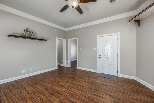 a view of an empty room with wooden floor