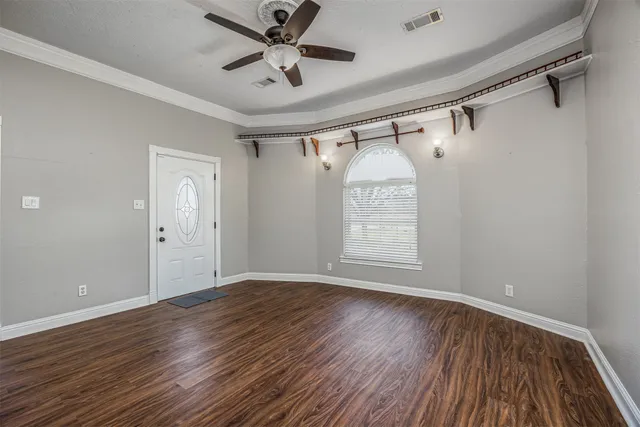 a view of a big room with wooden floor and windows