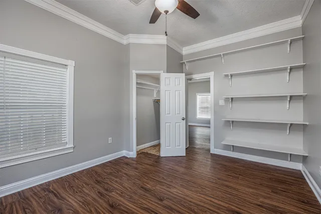 a view of an empty room with a window and wooden floor