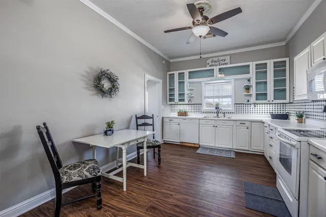 a kitchen with a table chairs and white cabinets