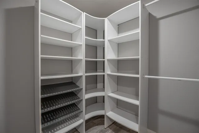 a view of walk in closet with empty racks