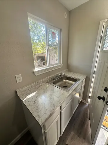a bathroom with a granite countertop sink and a window