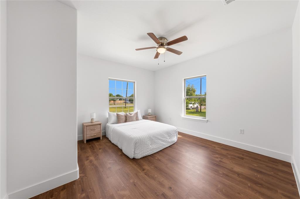 1128 Newton Road Ferris, TX 75125 - Photo 12 of 28 Spacious room featuring wood-finish flooring, white walls, and a ceiling fan with integrated lighting