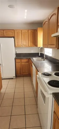 a kitchen with a sink a stove cabinets and a counter top space