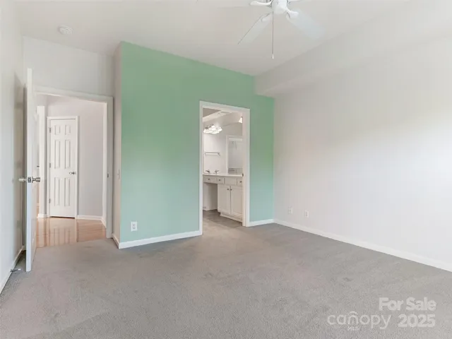 an empty room with an entryway and kitchen view