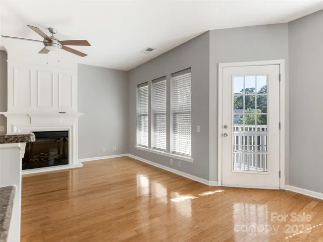 a view of an empty room with a fireplace and a window