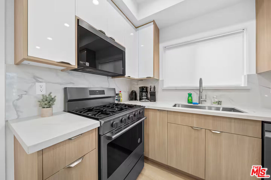 201 South Westlake Avenue, Unit 203 1/2 Los Angeles, CA 90057 - Photo 15 of 27 a kitchen with stainless steel appliances a sink a stove and microwave