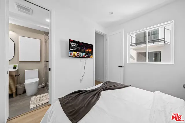 a bedroom with two beds and a painting on the wall