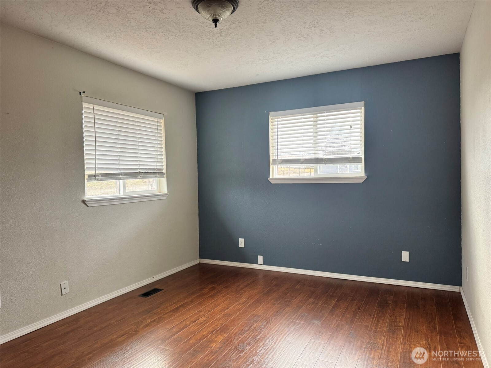 21 Orchard Loop North Tonasket, WA 98855 - Photo 12 of 23 an empty room with wooden floor and windows