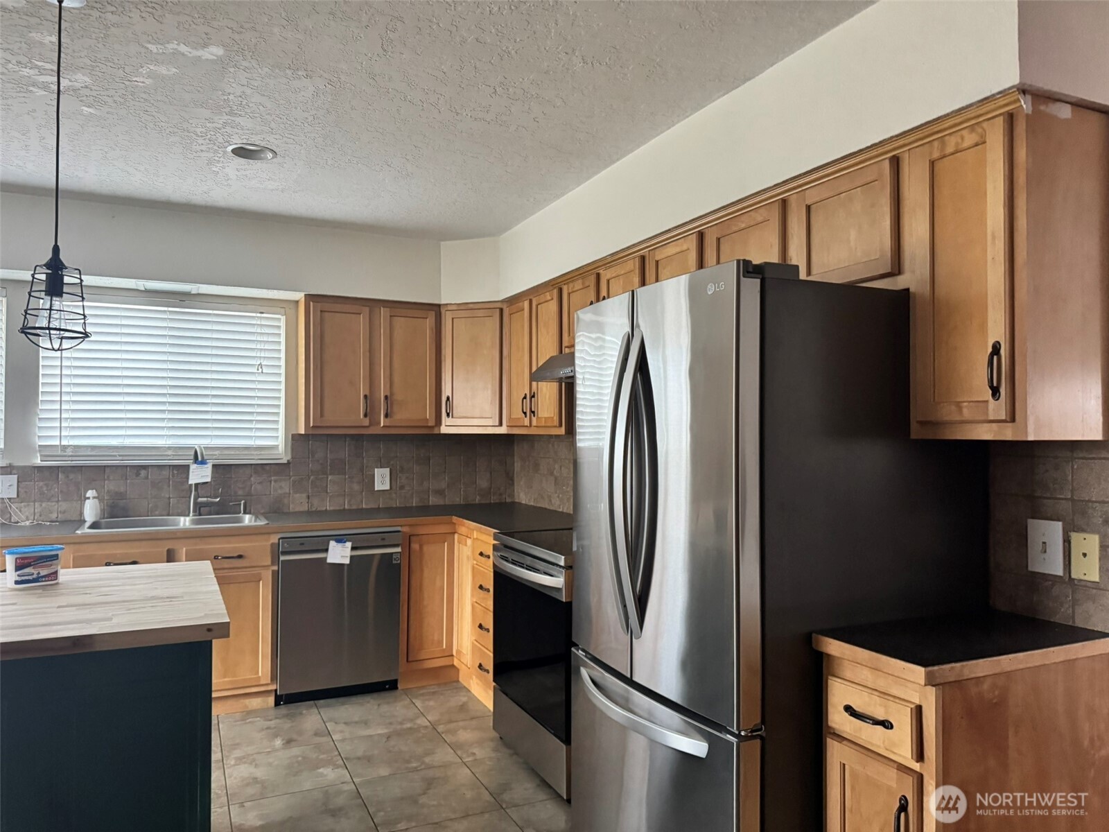 21 Orchard Loop North Tonasket, WA 98855 - Photo 3 of 23 a kitchen with stainless steel appliances granite countertop a refrigerator and a sink
