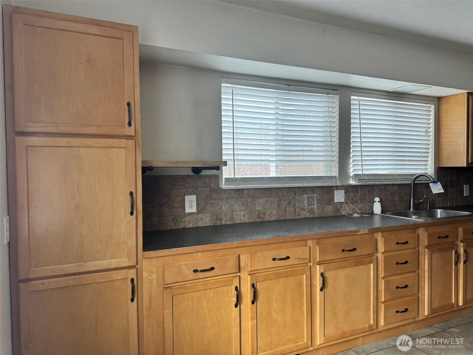 21 Orchard Loop North Tonasket, WA 98855 - Photo 6 of 23 a kitchen with granite countertop cabinets and a refrigerator