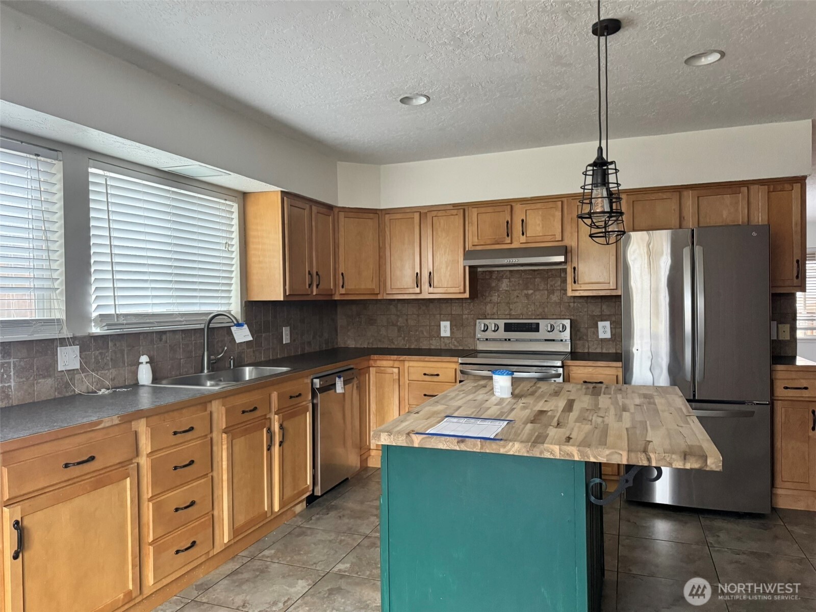 21 Orchard Loop North Tonasket, WA 98855 - Photo 7 of 23 a kitchen with a refrigerator a sink and cabinets