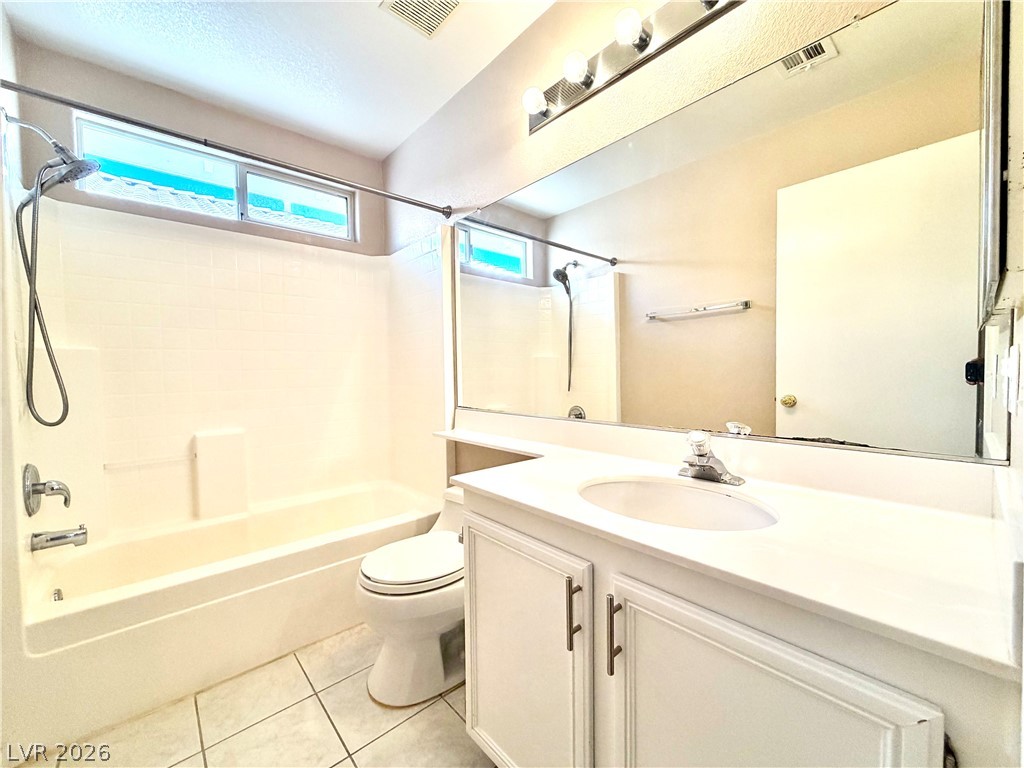 3936 Gold Point Street Las Vegas, NV 89129 - Photo 15 of 23 A well-lit bathroom with a bright window, a clean tub, and a vanity featuring ample counter space.