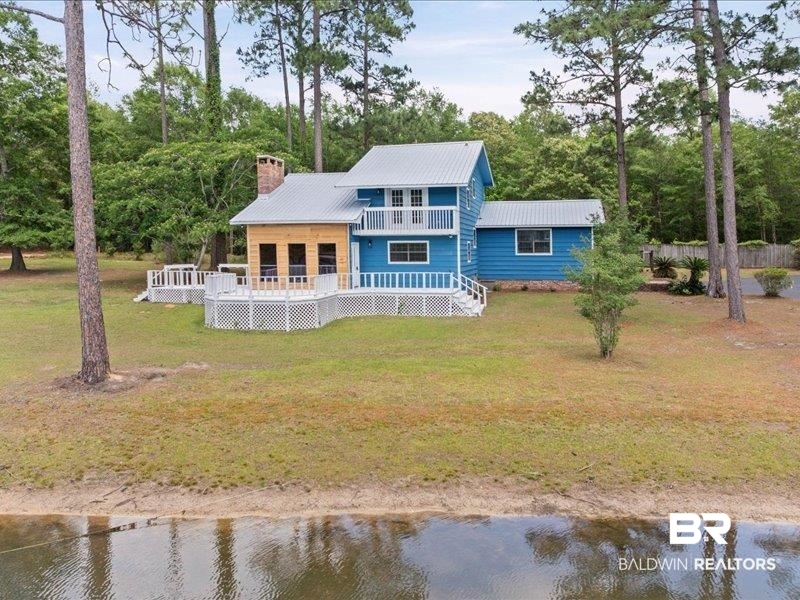 3160 Old Castleberry Road Brewton, AL 36426 - Photo 24 of 36 Waterfront property featuring a blue exterior, a metal roof, and a multi-level white lattice deck system
