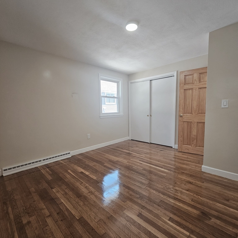 131 Itasca Street, Unit 2 Boston, MA 02126 - Photo 11 of 16 a view of empty room with wooden floor and fan