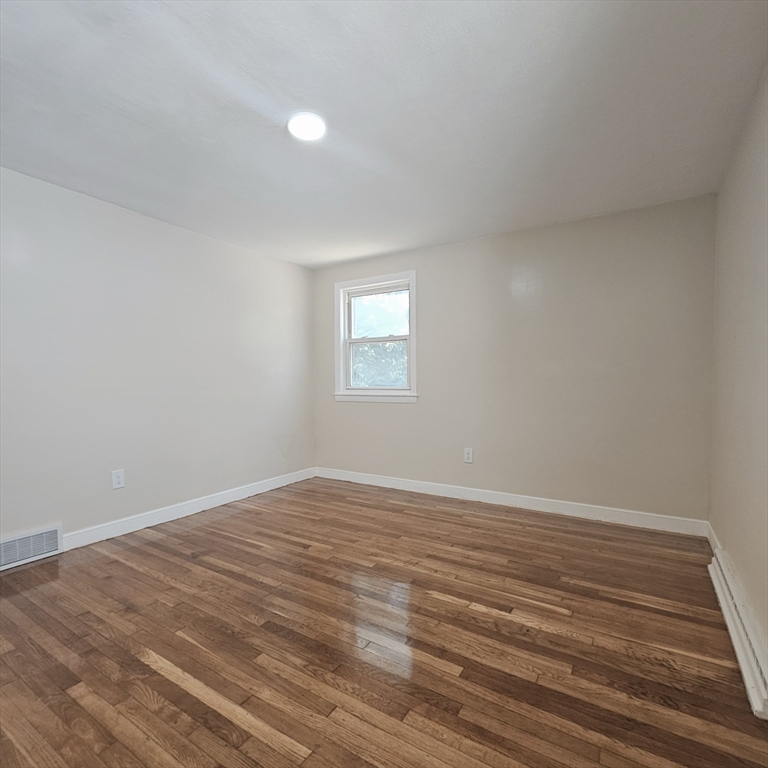 131 Itasca Street, Unit 2 Boston, MA 02126 - Photo 16 of 16 a view of an empty room with wooden floor and a window