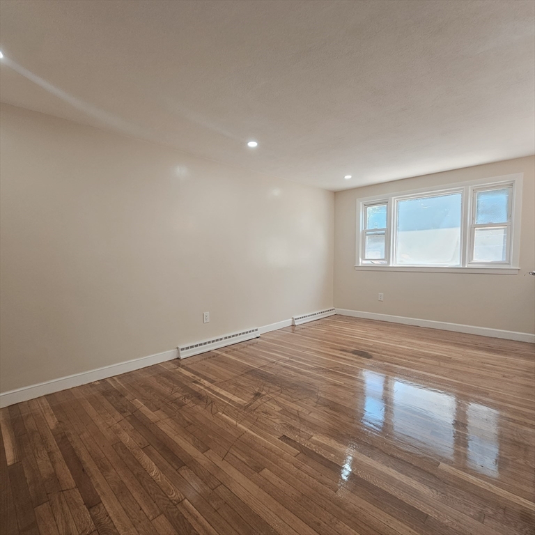 131 Itasca Street, Unit 2 Boston, MA 02126 - Photo 2 of 16 a view of empty room with wooden floor and fan