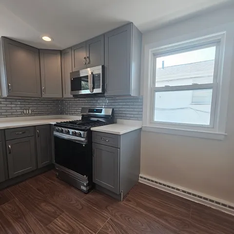 a kitchen with stainless steel appliances granite countertop a stove a sink and a microwave