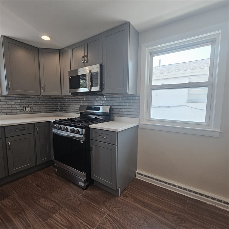 131 Itasca Street, Unit 2 Boston, MA 02126 - Photo 4 of 16 a kitchen with stainless steel appliances granite countertop a stove a sink and a microwave