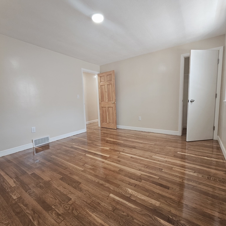131 Itasca Street, Unit 2 Boston, MA 02126 - Photo 9 of 16 a view of an empty room with wooden floor
