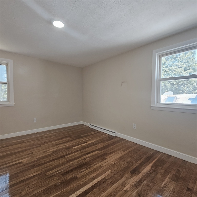 131 Itasca Street, Unit 2 Boston, MA 02126 - Photo 10 of 16 a view of an empty room with wooden floor and a window