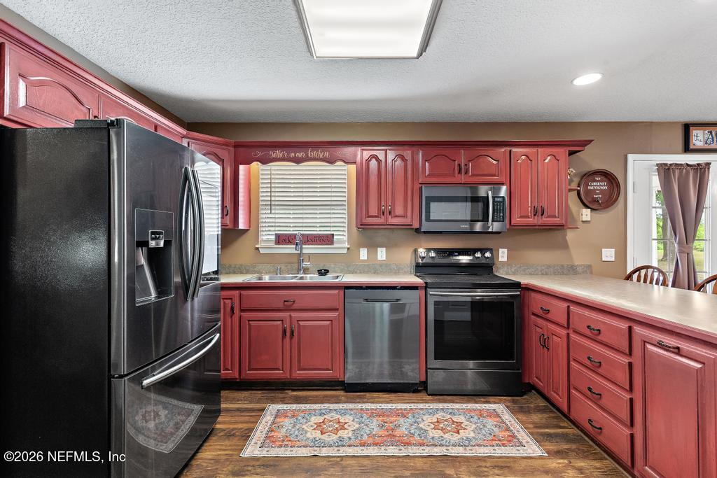 28317 Pike Road Hilliard, FL 32046 - Photo 17 of 42 a kitchen with stainless steel appliances granite countertop a refrigerator stove and sink