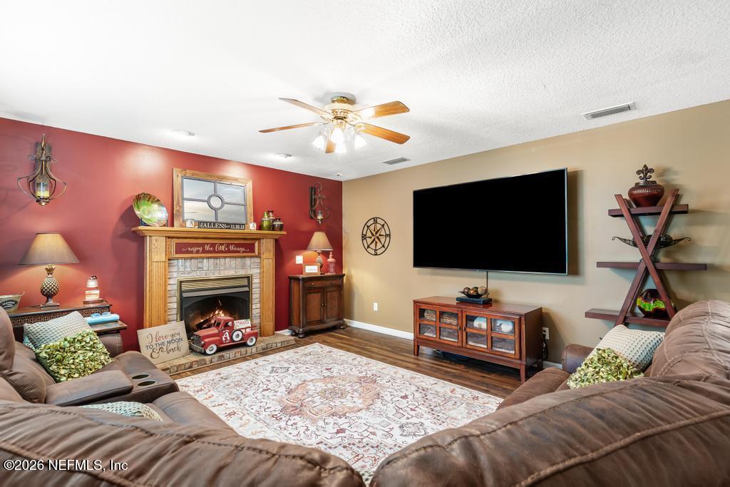 28317 Pike Road Hilliard, FL 32046 - Photo 19 of 42 a living room with furniture a flat screen tv and a fireplace
