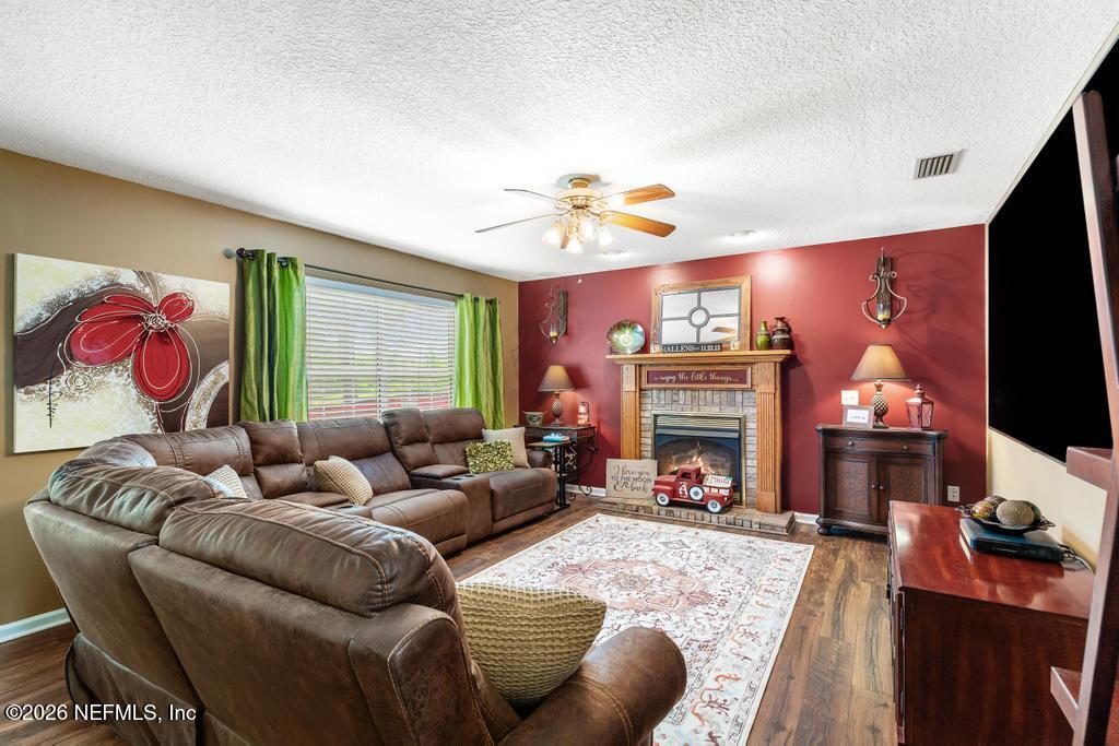 28317 Pike Road Hilliard, FL 32046 - Photo 20 of 42 a living room with furniture flat screen tv and a fireplace