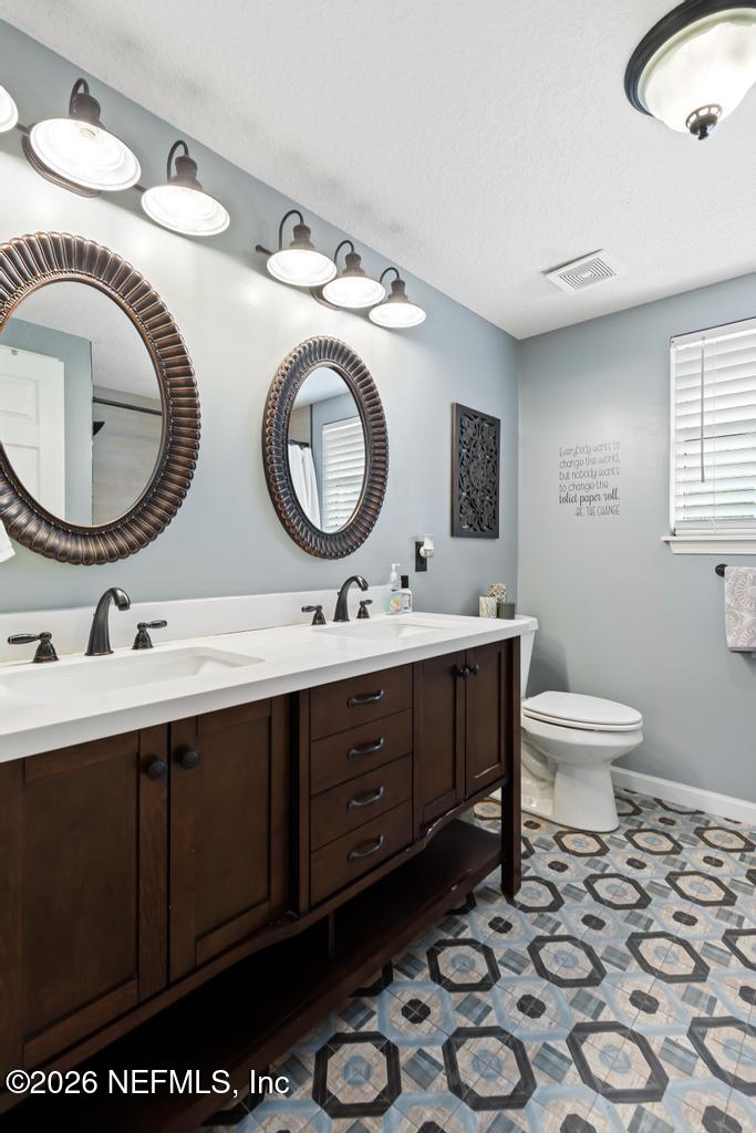 28317 Pike Road Hilliard, FL 32046 - Photo 28 of 42 a bathroom with a toilet mirror vanity and sink