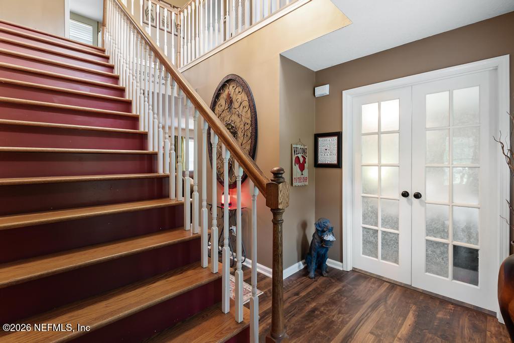28317 Pike Road Hilliard, FL 32046 - Photo 7 of 42 a view of a hallway with wooden floor and staircase