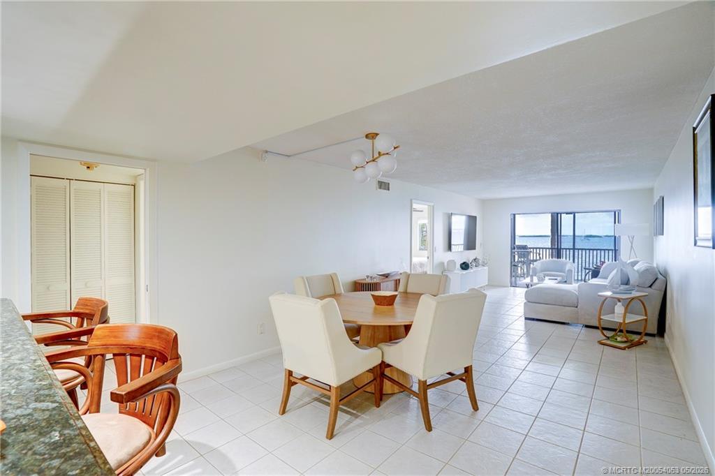 10 Northeast Plantation Road, Unit 101 Jensen Beach, FL 34957 - Photo 9 of 53 a dining room with furniture and wooden floor