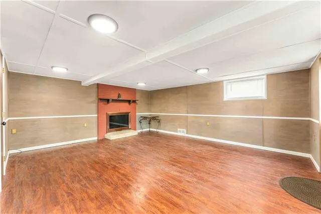 a view of an empty room with a fireplace and a window