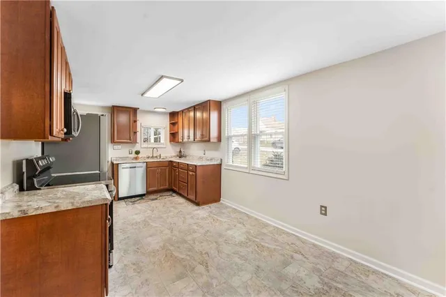 a kitchen with granite countertop a sink stainless steel appliances and cabinets