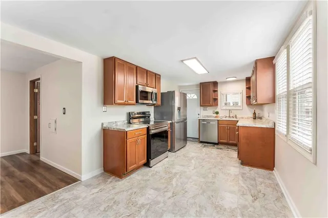 a kitchen with stainless steel appliances a refrigerator a sink dishwasher stove and oven