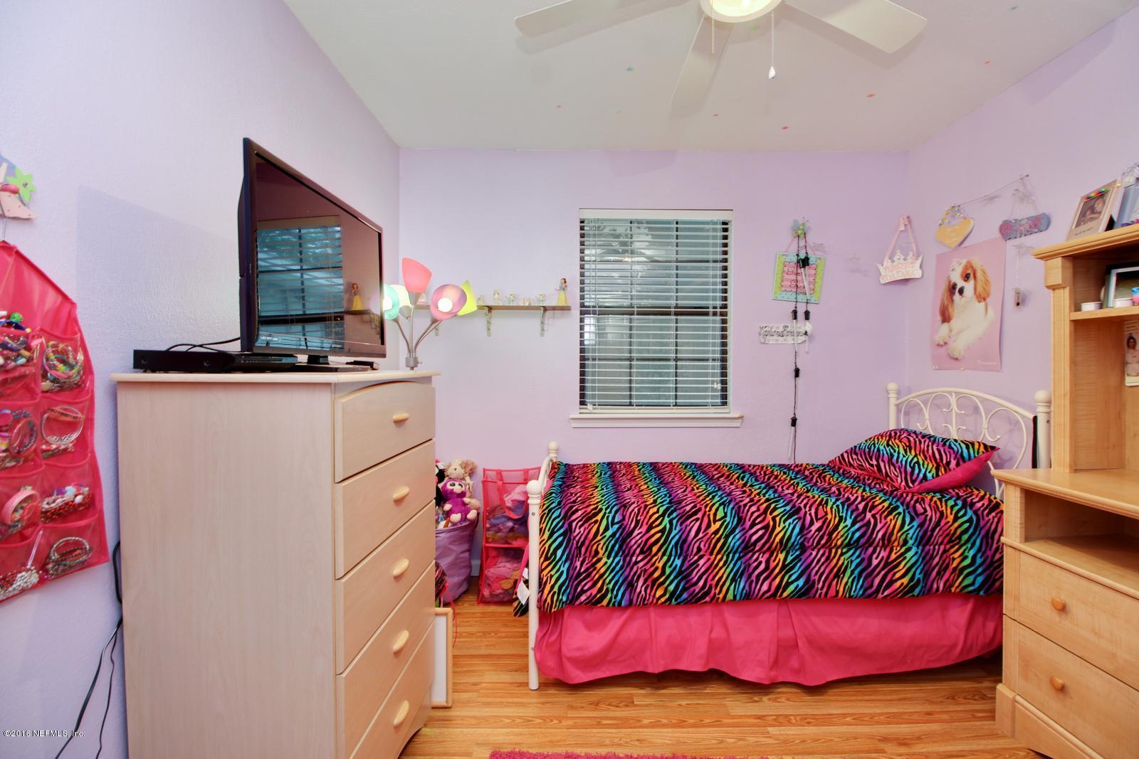 445 Sigsbee Road Orange Park, FL 32073 - Photo 16 of 32 a bedroom with a bed and a flat screen tv