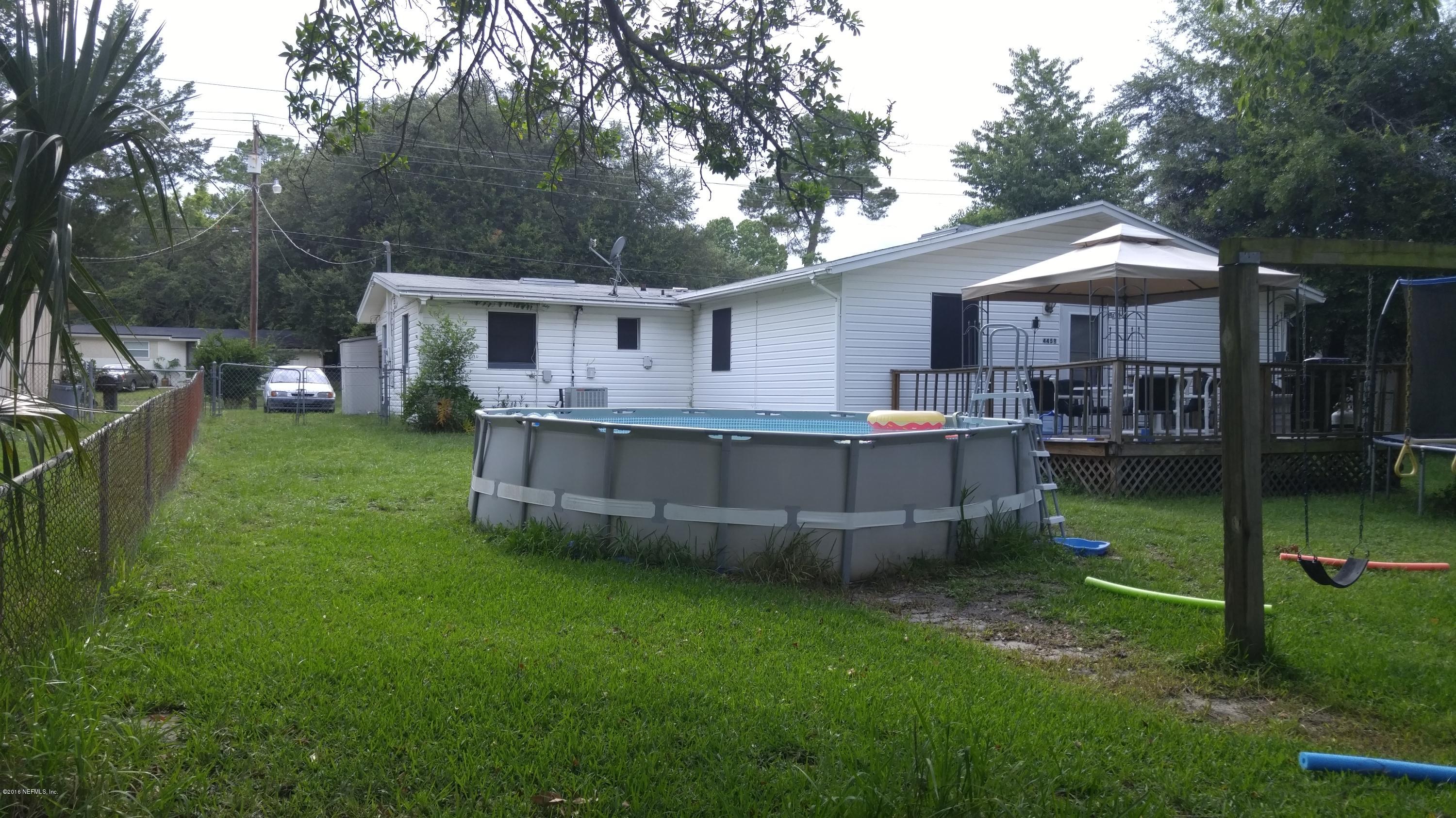 445 Sigsbee Road Orange Park, FL 32073 - Photo 32 of 32 a backyard of a house with barbeque oven and outdoor seating