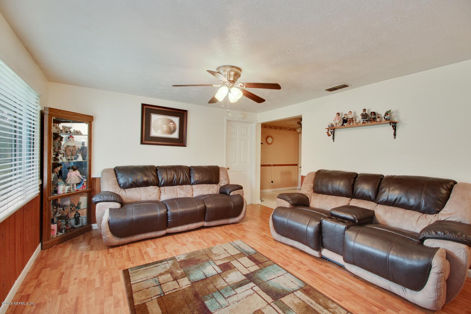 445 Sigsbee Road Orange Park, FL 32073 - Photo 4 of 32 a living room with furniture ceiling fan and a rug