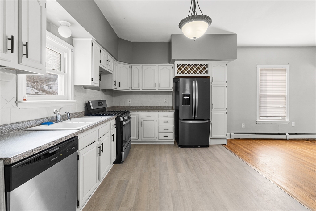 640 South Main Street Fall River, MA 02721 - Photo 3 of 33 a kitchen with stainless steel appliances granite countertop a refrigerator a stove a sink and white cabinets with wooden floor