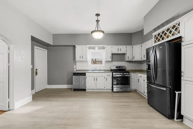 a kitchen with stainless steel appliances granite countertop a refrigerator a stove a sink and dishwasher