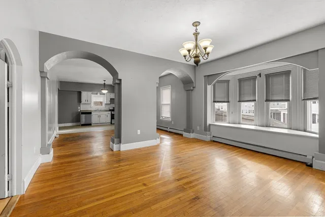a view of a room with wooden floor staircase and a living room