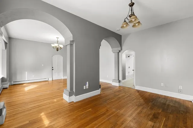 a view of a livingroom with wooden floor and a chandelier