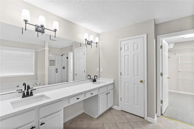 a spacious bathroom with double vanity a and a mirror