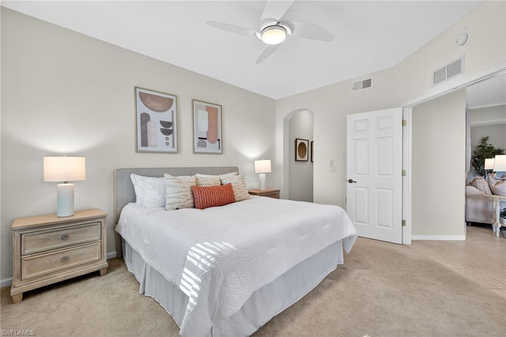 9201 Palmetto Ridge Drive, Unit 101 Estero, FL 34135 - Photo 13 of 29 Bedroom featuring ceiling fan, light colored carpet, and arched walkways