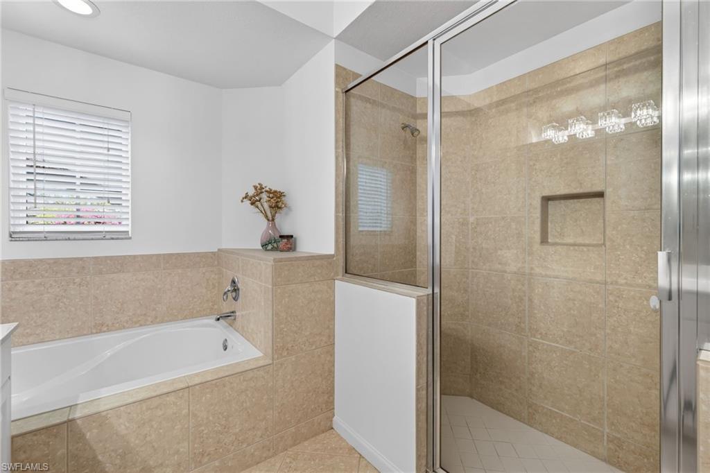 9201 Palmetto Ridge Drive, Unit 101 Estero, FL 34135 - Photo 14 of 29 Full bath with a shower stall, a bath, and vanity