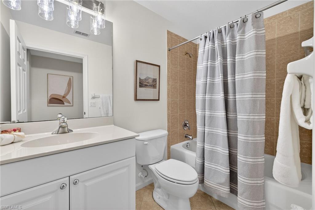 9201 Palmetto Ridge Drive, Unit 101 Estero, FL 34135 - Photo 18 of 29 Full bathroom with vanity, shower / bathtub combination with curtain, and light tile patterned flooring