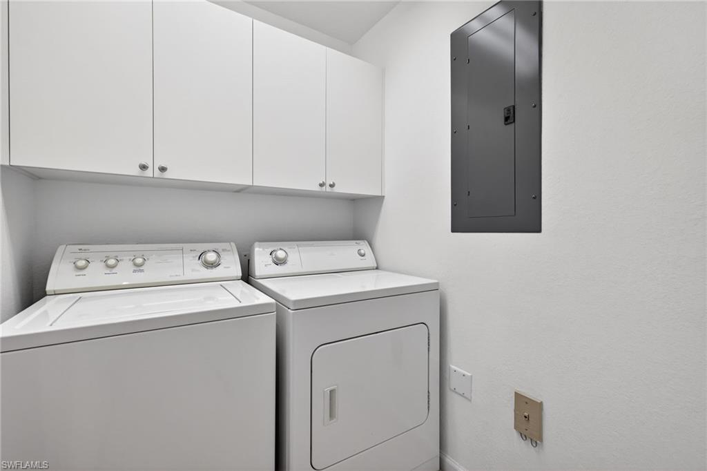 9201 Palmetto Ridge Drive, Unit 101 Estero, FL 34135 - Photo 19 of 29 Laundry room featuring cabinet space and washing machine and dryer