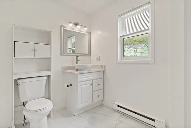 a bathroom with a toilet sink and mirror