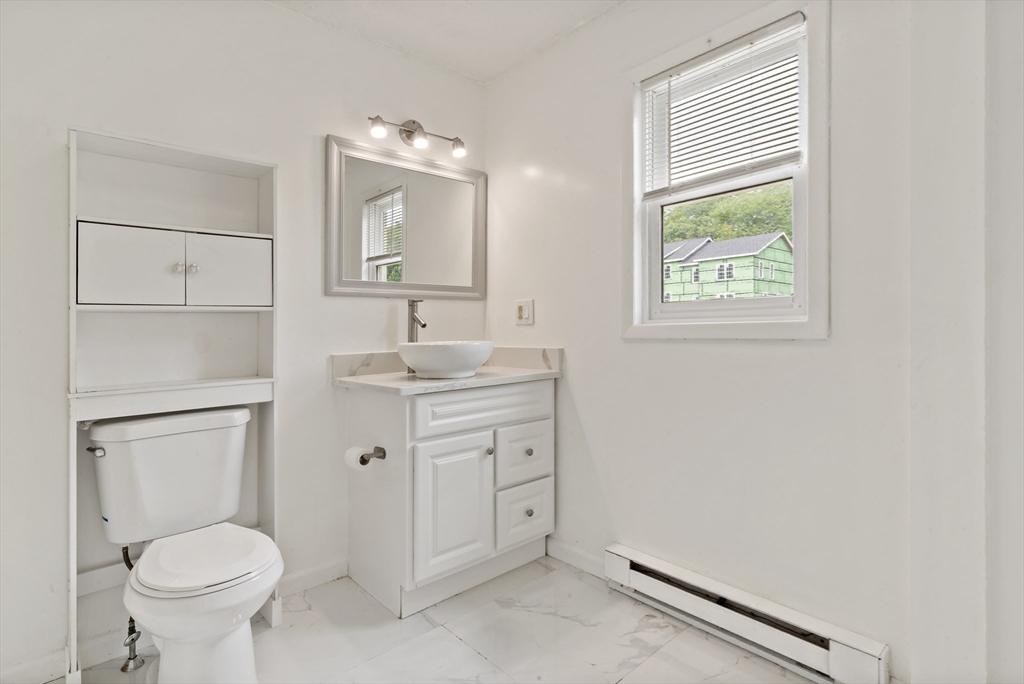 45 Fourth Street, Unit RIGHT Worcester, MA 01602 - Photo 12 of 21 a bathroom with a toilet sink and mirror