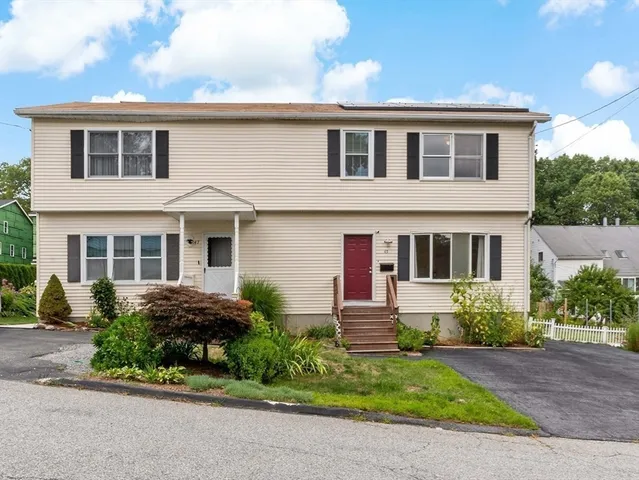 a front view of a house with a yard and outdoor seating